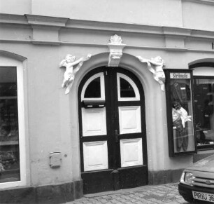 Bad Schandau, Poststraße 1. Wohnhaus mit Ladeneinbau (1880/1899, Kernbau älter). Rundbogenportal mit Putti