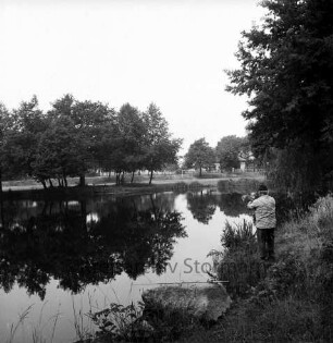Baggerkuhlenteich: vorn rechts Angler: rechts und hinten links Bäume: dahinter Behelfsheimsiedlung Baggerkuhle