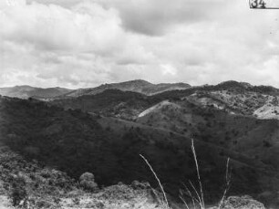Landschaft : Blick von einer Anhöhe in das bewaldete Tal und auf die bergige Umgebung