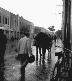 Straßenszene mit Passanten im Regen
