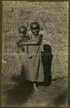 Wadschagga-Mädchen mit einem Kleinkind auf dem Arm