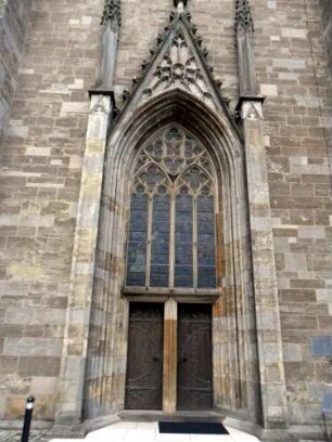 Stadtkirche - Kirchturm von Westen-Erdgeschoß mit gotischem Hochportal (profiliertes Gewände mit darübigem Ma0werkfenster)
