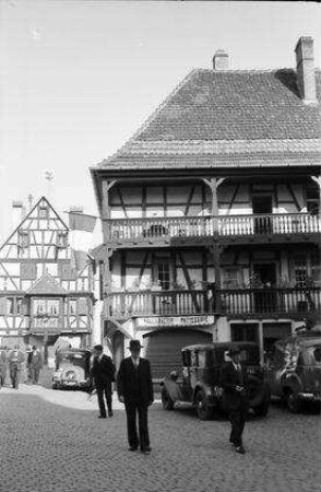 Turckheim: Gasse am Tor und Kirchturm, rechts Fachwerkhaus mit Balkons