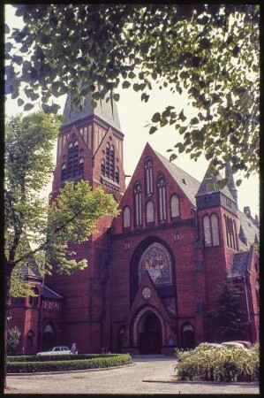 Vorderansicht der Auenkirche mit Pfarrhaus