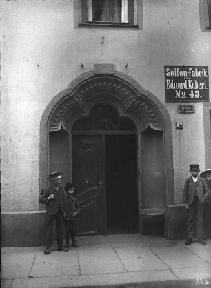 Blick auf Renaissance-Portal - Gebäude einer Seifenfabrik. Bildmitte und Rechte Bildseite - jeweils zwei Kinder links und rechts des Portals