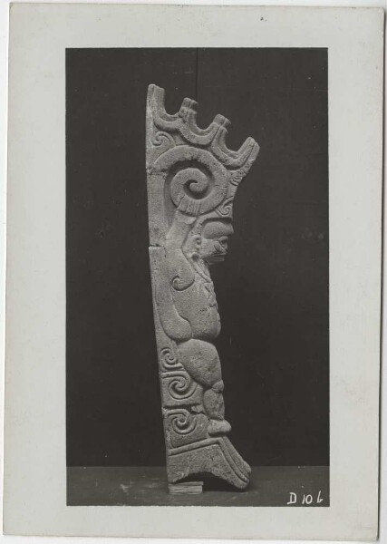 Dancing monkey with the scroll breast ornament of Macuilxochitl, grasping its upwardly curled tail with both hands, crenellated crown. -Palma- Side view.