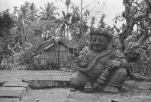 Dämonenfigur : Tempelskulptur in einer Landschaft mit Palmen