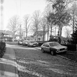 Kirchenweg: Polizei: Verkehrskontrolle: am Straßenrand rechts und hinten Polizeiauto und mehrere Pkw: rechts hinter Pkw Polizist und Fahrer: vorn Kopfsteinpflaster