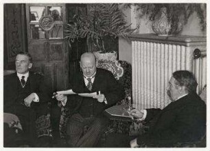 Gipfeltreffen zur deutsch-französischen Verständigung in Lugano, Gustav Stresemann sieht sich Erich Salomon Fotografien an. von links: Austen Chamberlain, Gustav Stresemann, Aristide Briand
