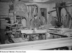 Arbeiter beim Sägen von Brettern