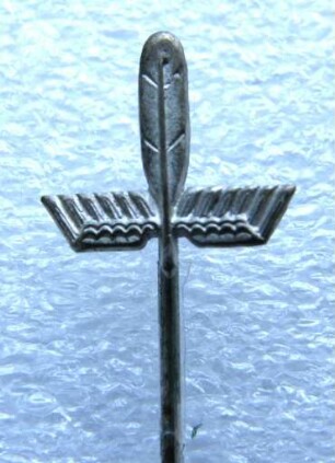 Stenographenabzeichen (Geflügelte Feder) Deutsche Einheitskurzschrift (mit langer Nadel) : Sammlung Beinhorn. Stenographenabzeichen (Geflügelte Feder) Deutsche Einheitskurzschrift (mit langer Nadel). Metall; Maße (ohne Nadel) 12,5 x 13 mm (nach 1924). Dresden: SLUB R c 0250