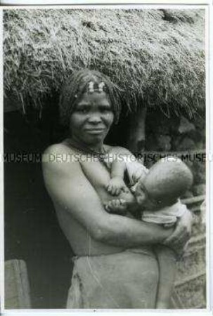 Einheimische Mutter mit Säuglein, der an ihrer Brust saugt, Afrika