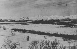 Schneelandschaft : Blick über eine Schneelandschaft. Im Vordergrund läuft eine Person auf Ski