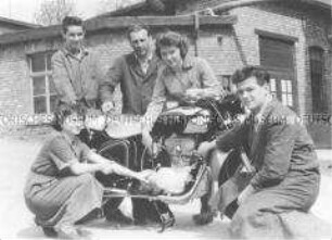 Gruppe von Arbeitern mit einem Motorrad