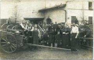 Gruppenbild von Landarbeitern (?) mit Kutschen und Wagen