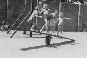 Betriebskindergarten der VEB Stralauer Glaswerke : Kinder auf einem Spielplatz auf einer Wippe