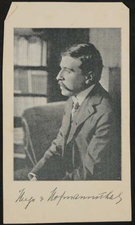 Hofmannsthal sitzt auf einem Sofa und schaut nach links, mit gedruckter Unterschrift (Autogrammkarte)