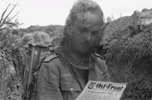 Zweiter Weltkrieg. Frontbilder. Sowjetunion. Franz Grasser mit Moskitonetz über dem Kopf beim Lesen der "Ost-Front"