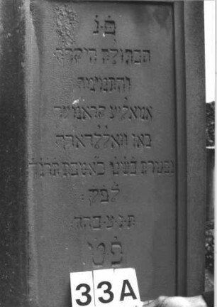 Grabstein 33 (Index: 99808473) Material: Sandstein Zustand: verwittert Maße HxBxT: 200x65x28 cm Beschreibung: konische Stele, getreppter Sockel, unterster Sockelteil rusticaartig, giebelartiger Abschluß mit Verdachung, rechteckiges Schriftfeld eingetieft Symbolik: seckszackiger Stern: Grabstein 33A