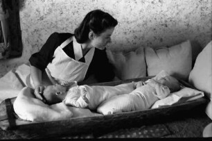 Bukarest: Institut für Ausbildung von Fürsorgeschwestern, Schwester versorgt Baby, liegend