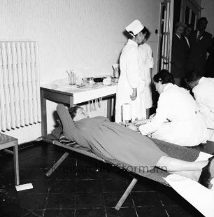 Deutsches Rotes Kreuz DRK: Volksschule: am Schweinemarkt: erste Blutentnahmeaktion der Zentrale des DRK-Blutspendedienstes Nord Lütjensee: Spenderin auf Liege: DRK-Krankenschwestern, Chefarzt des Blutspendedienstes Schuberth