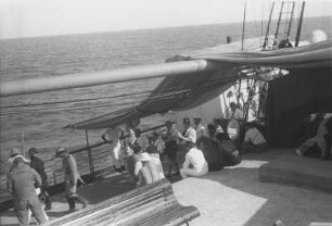 Äquatortaufe an Bord des Dampfers Usaramo : Blick auf Deck des Dampfers Usaramo. Ein paar der Passagiere schauen der Äquatortauf-Feier zu