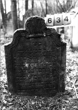 Grabstein 634 (Index: 99752488) Material: Sandstein Zustand: gut Maße HxBxT: 88x64x9 cm Beschreibung: Stele, geschwungen eingezogener Rundbogenabschluß, Schriftfeld eingetieft Symbolik: Muschel: Grabstein 634