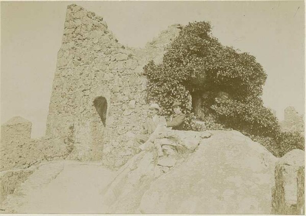 Two Europeans in front of a stone ruin