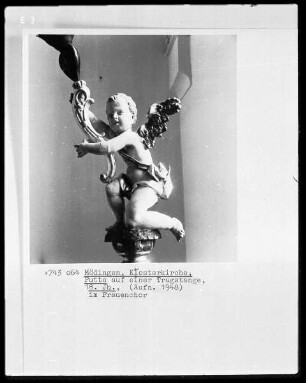 Putto auf einer Tragstange