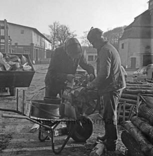 Forstbetriebsgemeinschaft Stormarn: Gut Blumendorf: Personen bändeln Kaminholz mit einer Maschine (links)