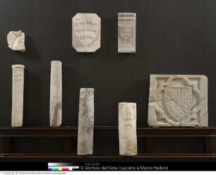 Fragmente von Säulen und Reliefs, darunter mehrere mit dem Wappen der Abtei