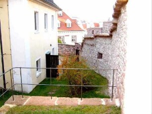 Kirchhof im Norden mit abgetreppter (aufsteigender) Kirchhofmauer (mit erhaltenen Konsolsteinen und Steinbrüstung des Wehrgangs)