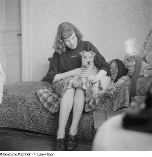Renate Rössing mit Hund auf einem Sofa sitzend