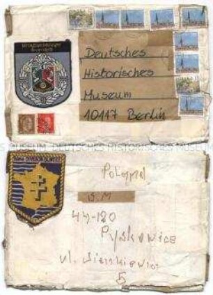 Briefumschlag aus Polen, adressiert an das DHM, frankiert mit polnischen Briefmarken, zusätzlich beklebt mit zwei Ärmelabzeichen der Fremdenlegion (vermutlich) und zwei Briefmarken aus der NS-Zeit