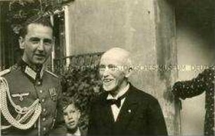 Tauf-Gesellschaft im Hof, Vater des Täuflings in Uniform
