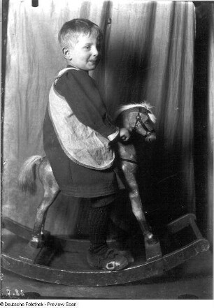 Karl Quarck, der Sohn des Malers Karl Quarck auf einem Schauckelpferd in der Wohnung, Marsdorfer Str. 5