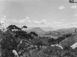 Landschaft : Blick von einer Anhöhe in das bewaldete Tal und auf die bergige Umgebung