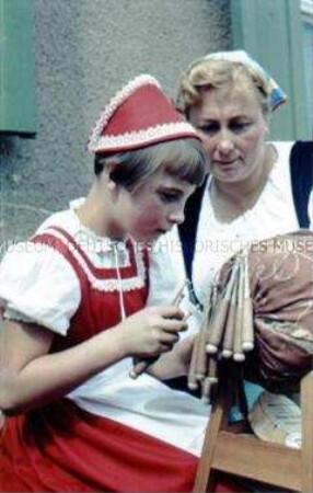 Klöppellehrerin aus Lautern (Sachsen) gibt Mädchen Unterricht