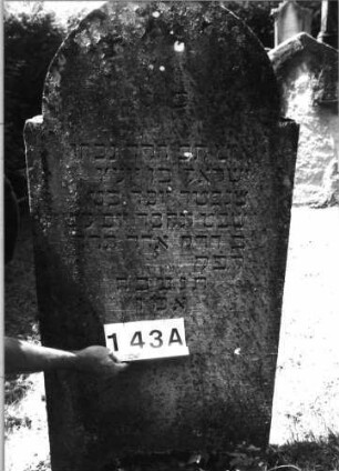 Grabstein 143 (Index: 100085463) Maße HxBxT: 140x65x16 cm Beschreibung: Stele, eingezog. Rundbogenabschl. , Schriftfeld eingetieft mit Maßwerk auf Vordersei: Grabstein 143A