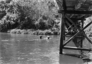 Brücke : Zwei Männer waschen sich in einem Fluss unterhalb einer Brücke.