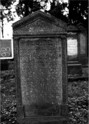 Grabstein 93 (Index: 100111193) Material: Sandstein Zustand: leicht verwittert Maße HxBxT: 139x66x11 cm Beschreibung: ädikulaartige Stele mit Halbsäulen, giebelartiger Abschluß mit Verdachung Symbolik: Blüte: Grabstein 93