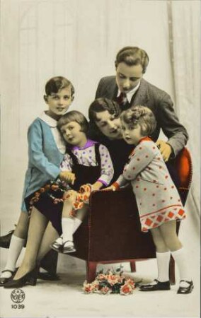 [Frau und Mann mit Kindern auf einem Sessel]