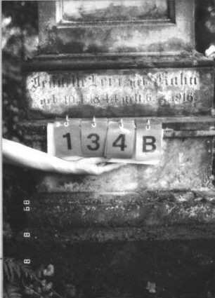 Grabstein 134 (Index: 99799458) Material: Sandstein, Schriftplatte Marmor Zustand: verwittert Maße HxBxT: 190x66x32 cm Beschreibung: Stele, Giebel mit Verdachung, Mittelpalmette, Seitenakrotere, rechteckige eingelassene Schriftplatte, getreppter Sockel: Grabstein 134B