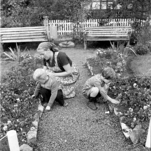 Alsfeld-Eifa. Frau mit zwei Kindern bei der Gartenarbeit, wohl in einem Stadtgarten