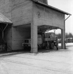 A 1: Bad Oldesloe / Rethwischfeld: Autobahnmeisterei: Betonsilo für Streugut, an Fassade Wanduhr: automatischer Streu-Lkw wird beladen: Mann beim Überwachen des Vorgangs: im Winter