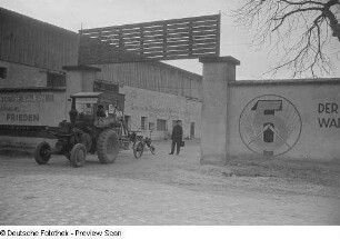 Traktor mit Pflug vor dem Eingangstor