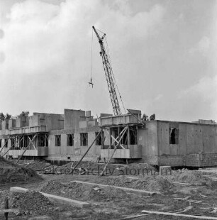 Klosterbergen: Bogenstraße: dreigeschossiger Wohnblock aus Fertigbetonteilen im Bau: auf erstem Geschoss Bauarbeiter: vorn Erdhaufen, Bretter und Baumaterial: hinten Mitte Baukran