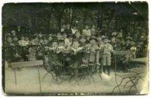 Jungengruppe mit Betreuerinnen in einem Gartenlokal