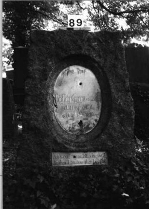 Grabstein 89 (Index: 100084944) Maße HxBxT: 130x80x45 cm Beschreibung: ovale/rechteck. Schriftplatte(Vorderseite), Schriftplatte(Rückseite)eingez. Rundbog Besonderheit: Hiob 1, 8 und 2, 3: Grabstein 89