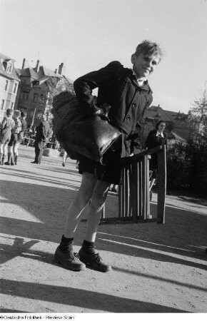 Portrait eines Jungen mit Klappstuhl und weiterem Gepäck anläßlich des 6. Leipziger Stadtparkrennens